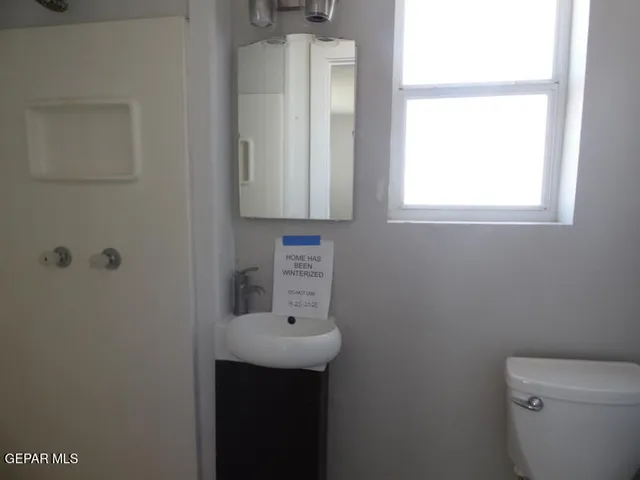 a bathroom with a sink a window and a toilet