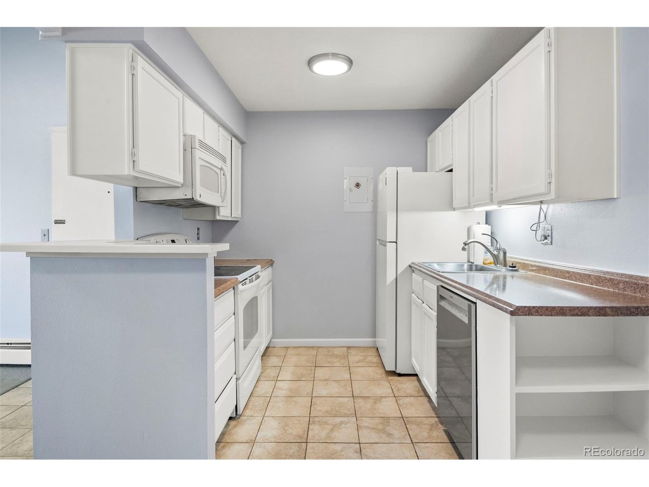 10150 East Virginia Avenue, Unit 2 Denver, CO 80247 - Photo 8 of 20 a kitchen with a sink a refrigerator and cabinets