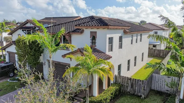 a view of a house with plants and wooden fence