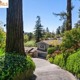 a front view of a house with a yard and fountain in middle