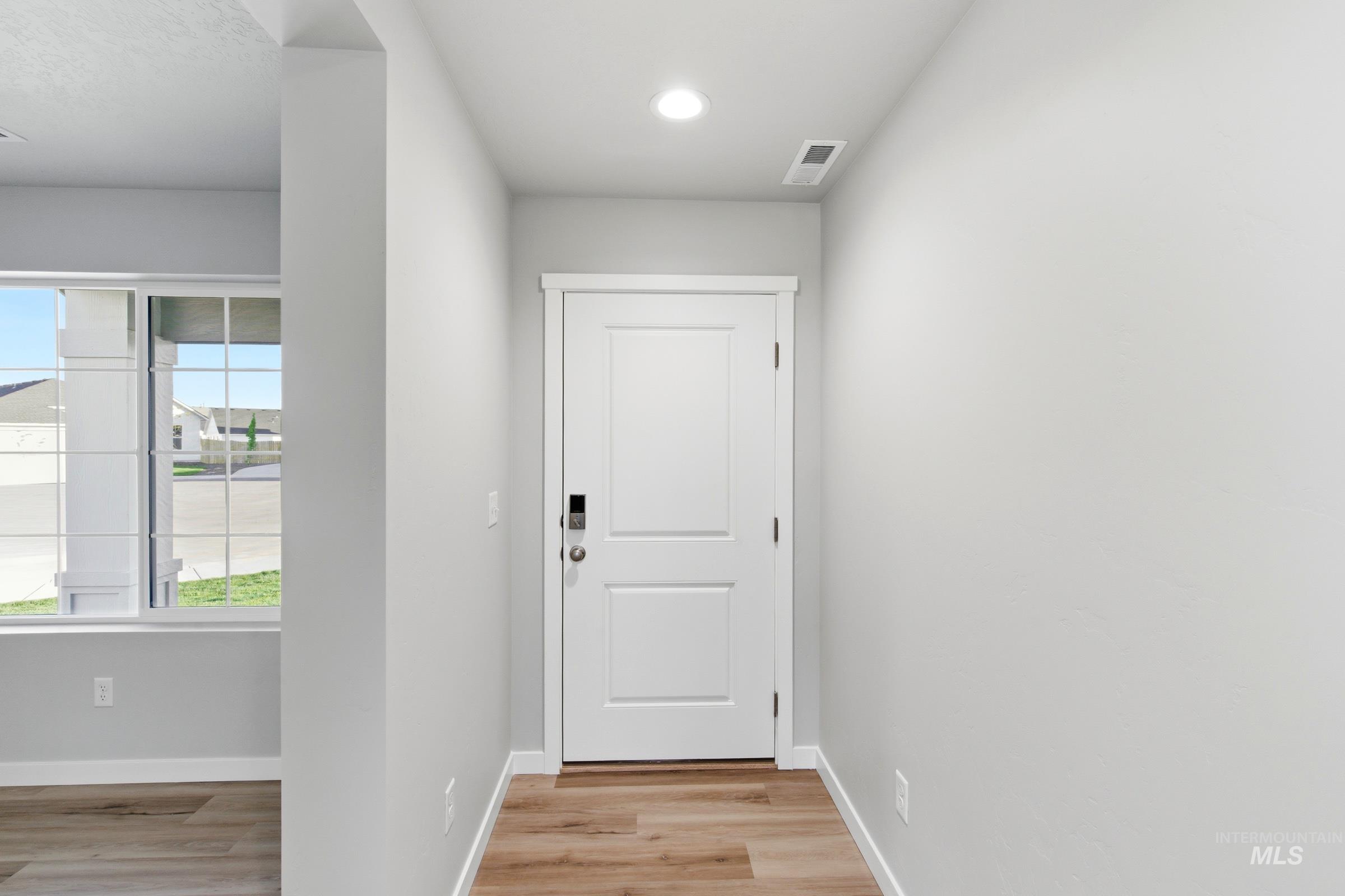 13709 Redway Court Caldwell, ID 83607 - Photo 2 of 28 Entryway featuring a two-panel door with smart lock hardware, wood-finish flooring, recessed lighting, and a broad window with grid detailing