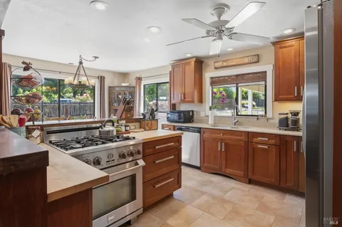 a kitchen with stainless steel appliances granite countertop a stove a sink and a refrigerator