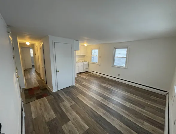 a view of empty room with window and wooden floor