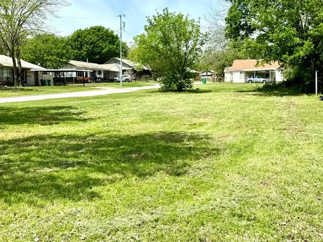 a front view of a house with a yard and trees