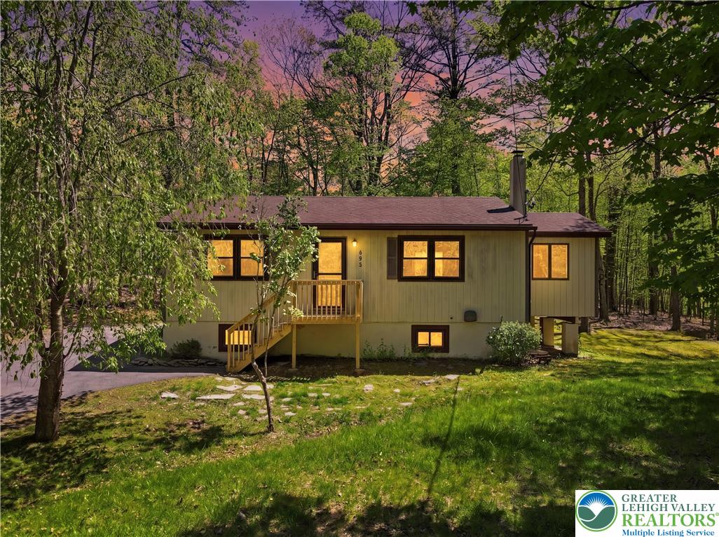 a view of a house with backyard and a tree