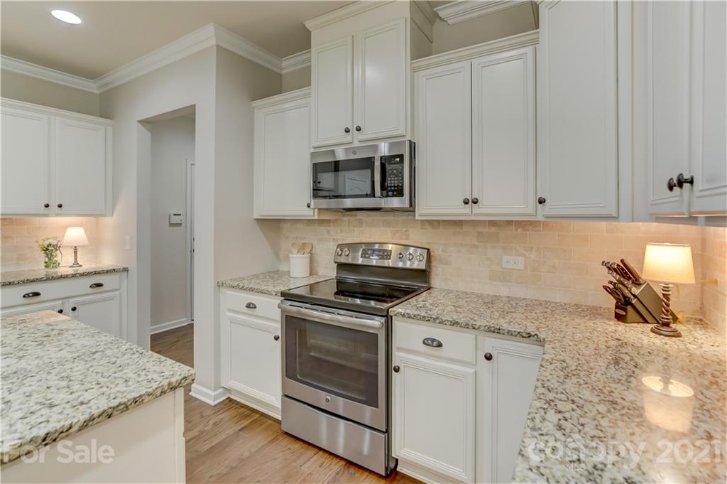 5202 Waterloo Drive Tega Cay, SC 29708 - Photo 20 of 44 a kitchen with granite countertop white cabinets and stainless steel appliances