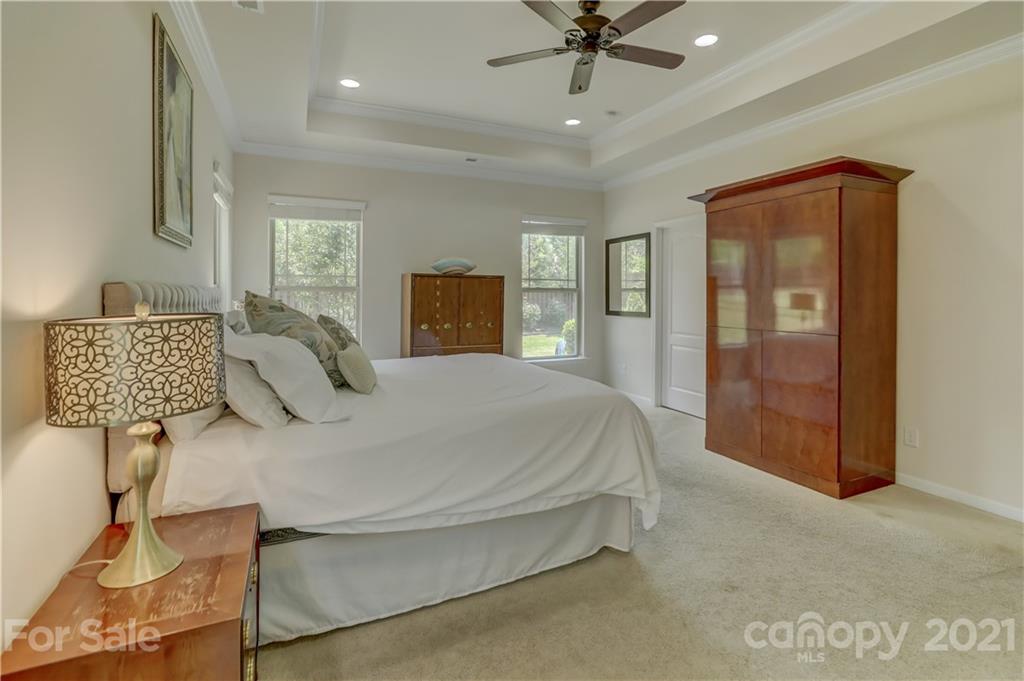5202 Waterloo Drive Tega Cay, SC 29708 - Photo 22 of 44 a spacious bedroom with a bed and dresser with mirror