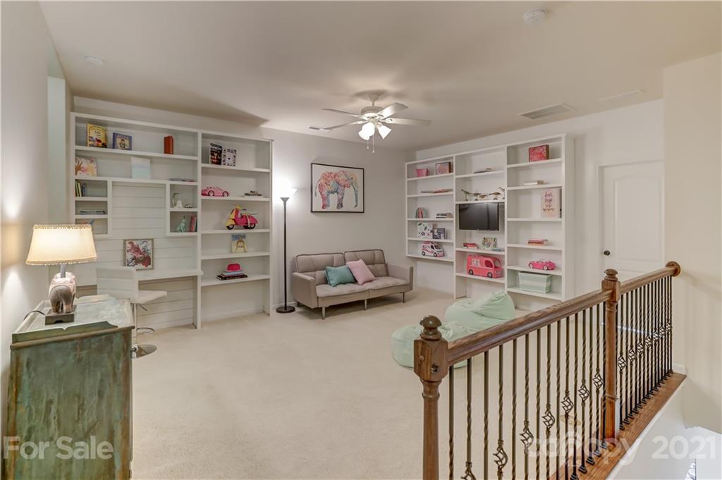 5202 Waterloo Drive Tega Cay, SC 29708 - Photo 30 of 44 a bedroom with furniture a flat screen tv and a book shelf