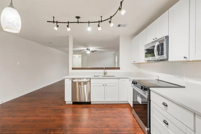 a kitchen with a stove cabinets and wooden floor