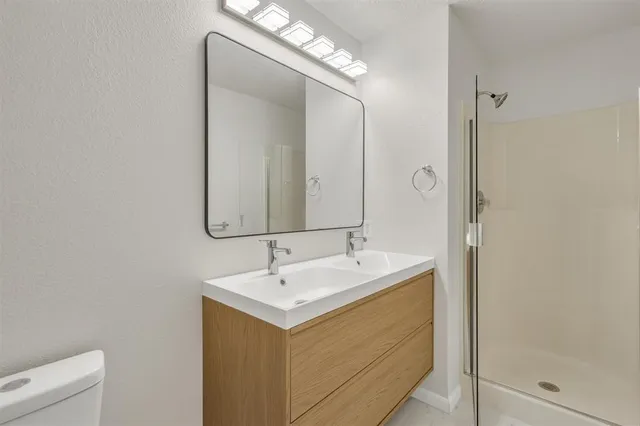a bathroom with a double vanity sink mirror and shower