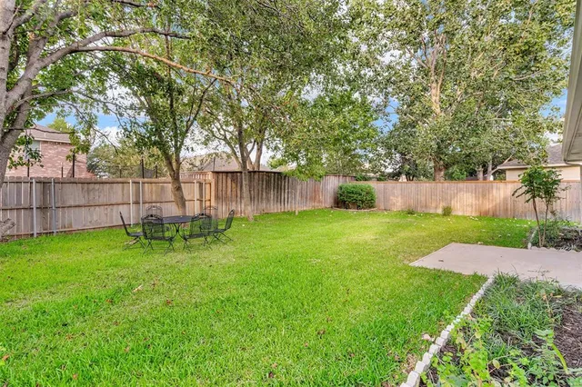 a view of a backyard with wooden fence
