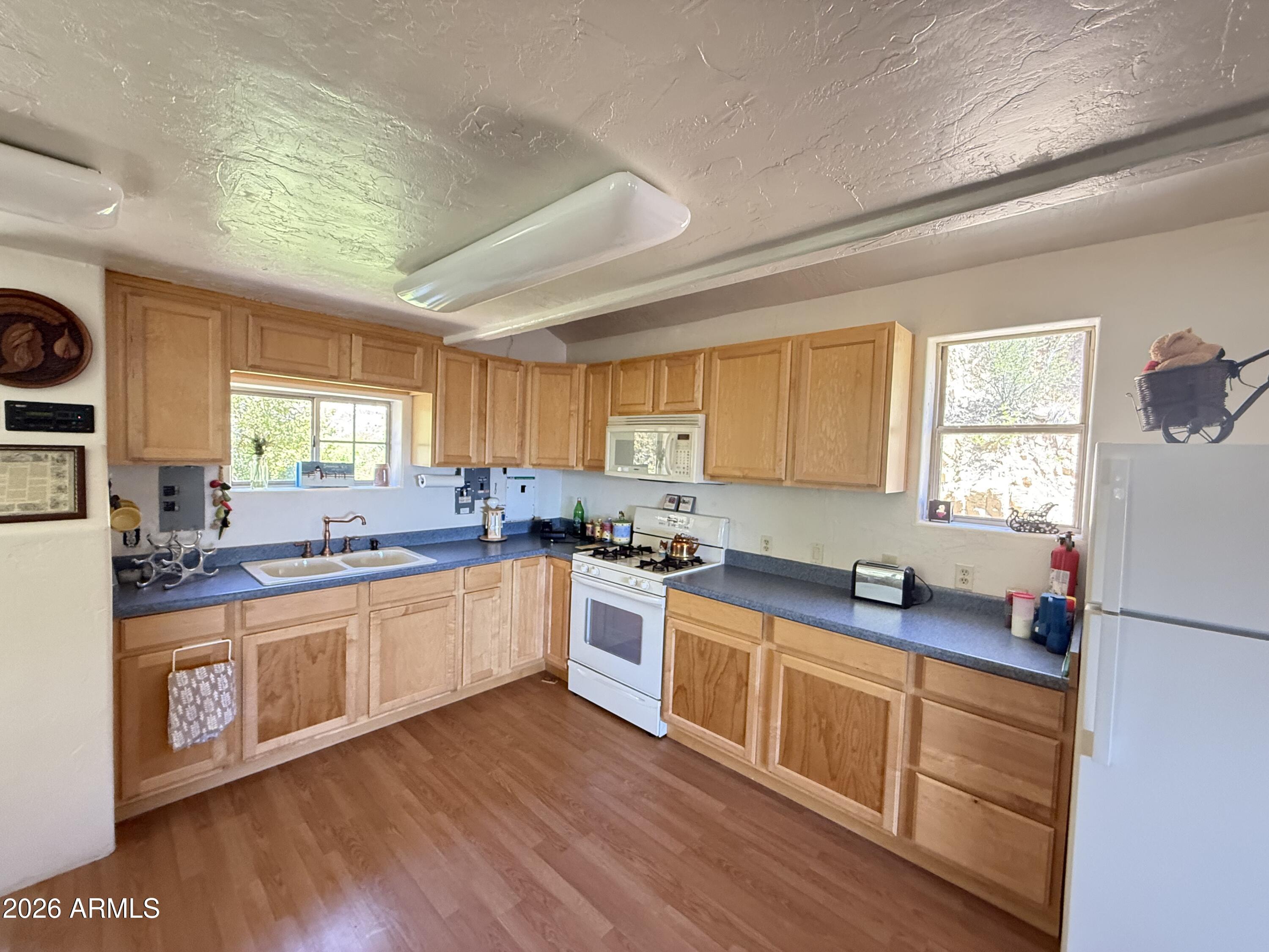 22406 South Eagle Mine Road Crown King, AZ 86343 - Photo 6 of 20 a large kitchen with stainless steel appliances granite countertop a stove a sink dishwasher a refrigerator and white cabinets with wooden floor