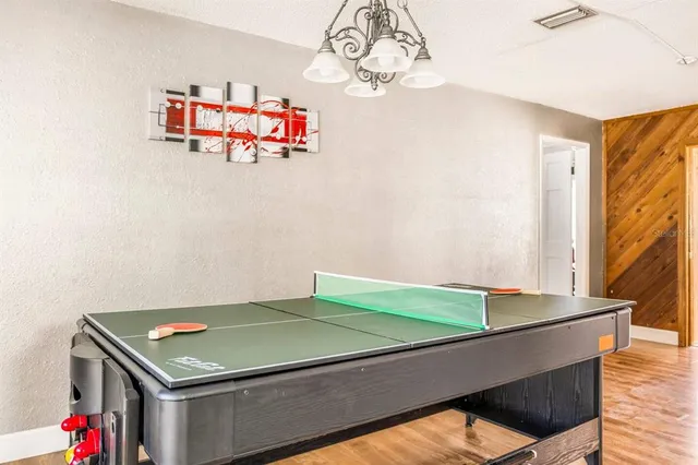 a room with pool table and wooden floor