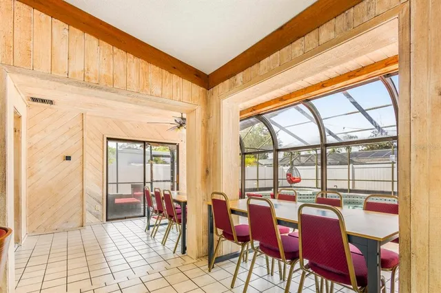 a dining room with furniture and a floor to ceiling window