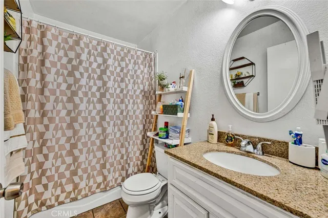 a bathroom with a granite countertop sink mirror and toilet