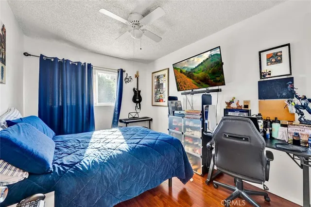 a bedroom with a bed a flat screen tv and dresser