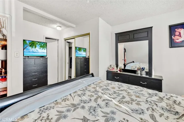 a bed room with a bed mirror and a dresser