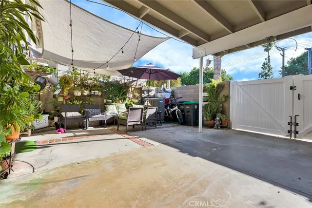 a view of the patio with a table and chairs under an umbrella