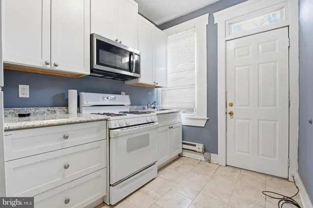a kitchen with granite countertop white cabinets stainless steel appliances and sink