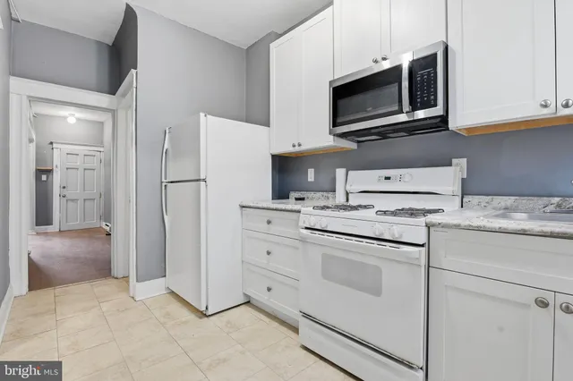a kitchen with granite countertop white cabinets stainless steel appliances and sink