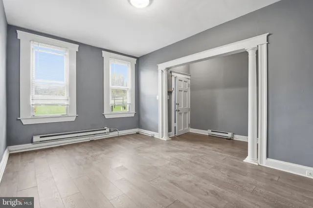 an empty room with window and wooden floor