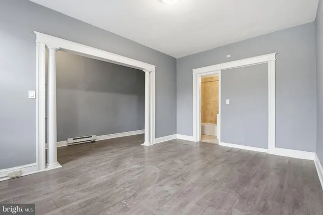 a view of an empty room with wooden floor and closet