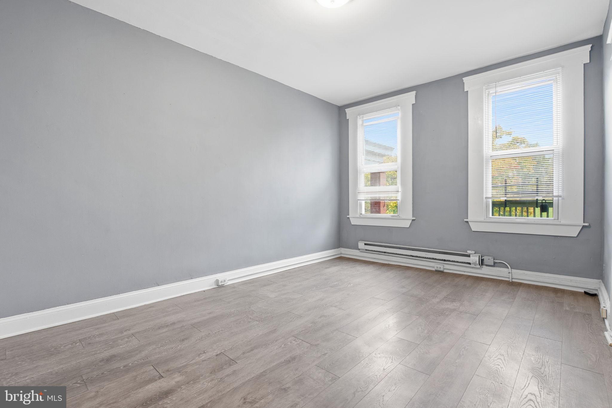 5 South Wickham Road, Unit 1 Baltimore, MD 21229 - Photo 5 of 17 a view of an empty room with wooden floor and a window