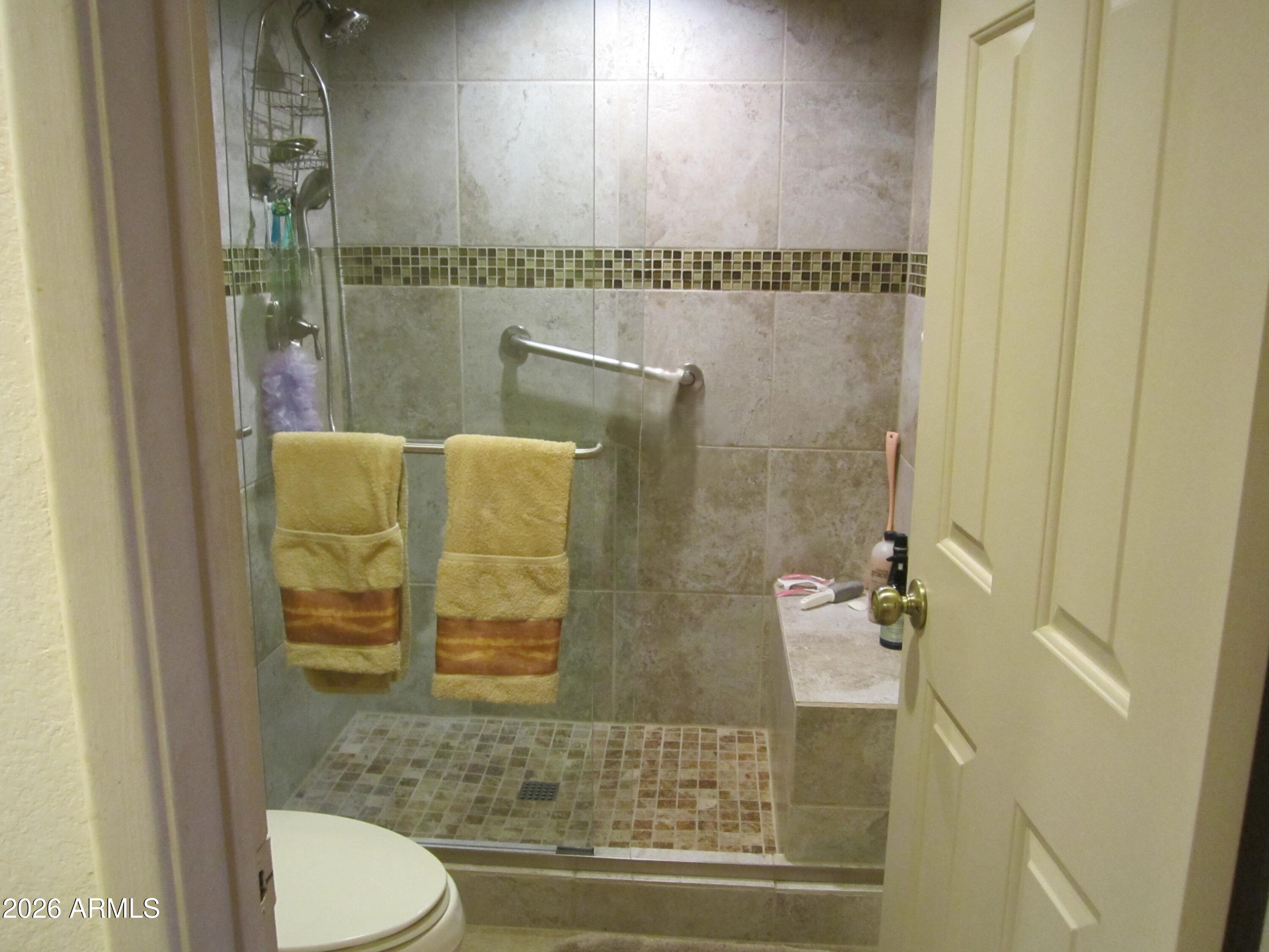 4303 East Cactus Road, Unit 423 Phoenix, AZ 85032 - Photo 11 of 39 a bathroom with a toilet and a shower