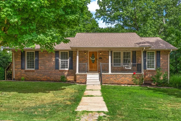 a front view of a house with a garden and yard