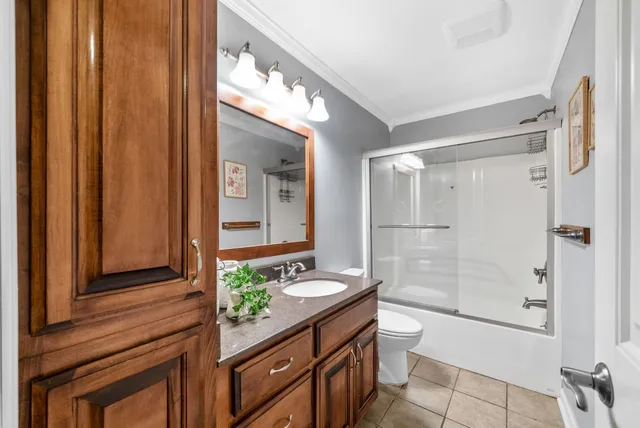 a bathroom with a granite countertop sink a toilet and shower