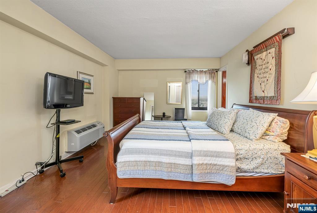 125 Prospect Avenue, Unit 16C Hackensack, NJ 07601 - Photo 25 of 35 a bedroom with a bed and a flat screen tv