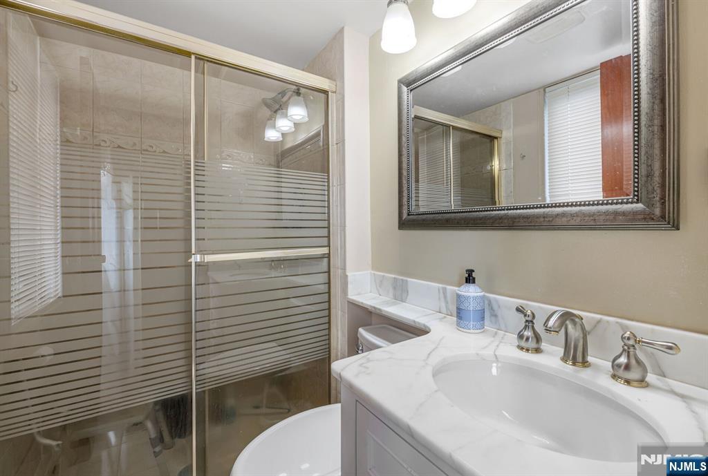 125 Prospect Avenue, Unit 16C Hackensack, NJ 07601 - Photo 26 of 35 a bathroom with a sink a toilet and shower