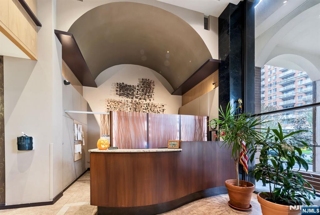 125 Prospect Avenue, Unit 16C Hackensack, NJ 07601 - Photo 33 of 35 a vase of flowers sitting on a table near a potted plant