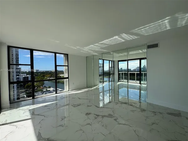 an empty room with sliding glass door and chandelier