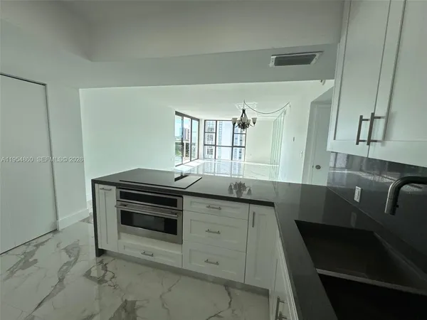 a kitchen with granite countertop a sink and cabinets