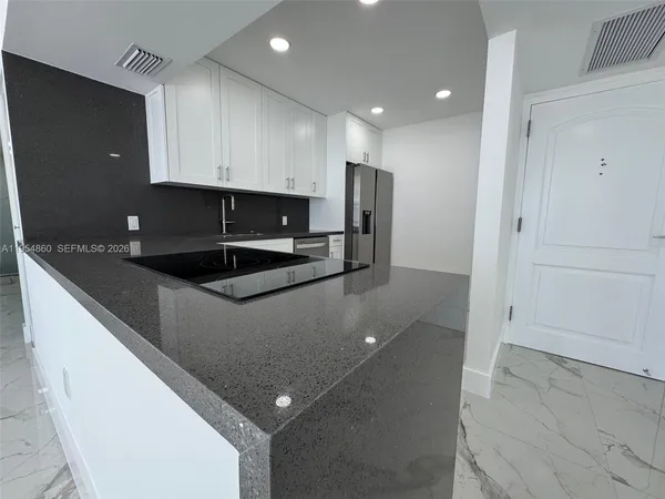 a kitchen with stainless steel appliances granite countertop a refrigerator and a stove