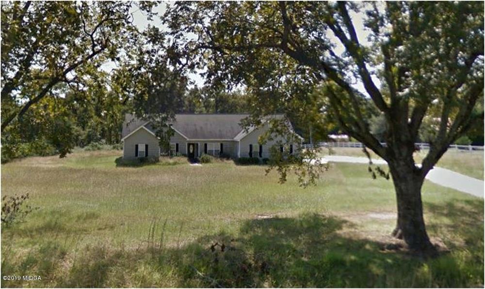 a view of a house with backyard and a tree