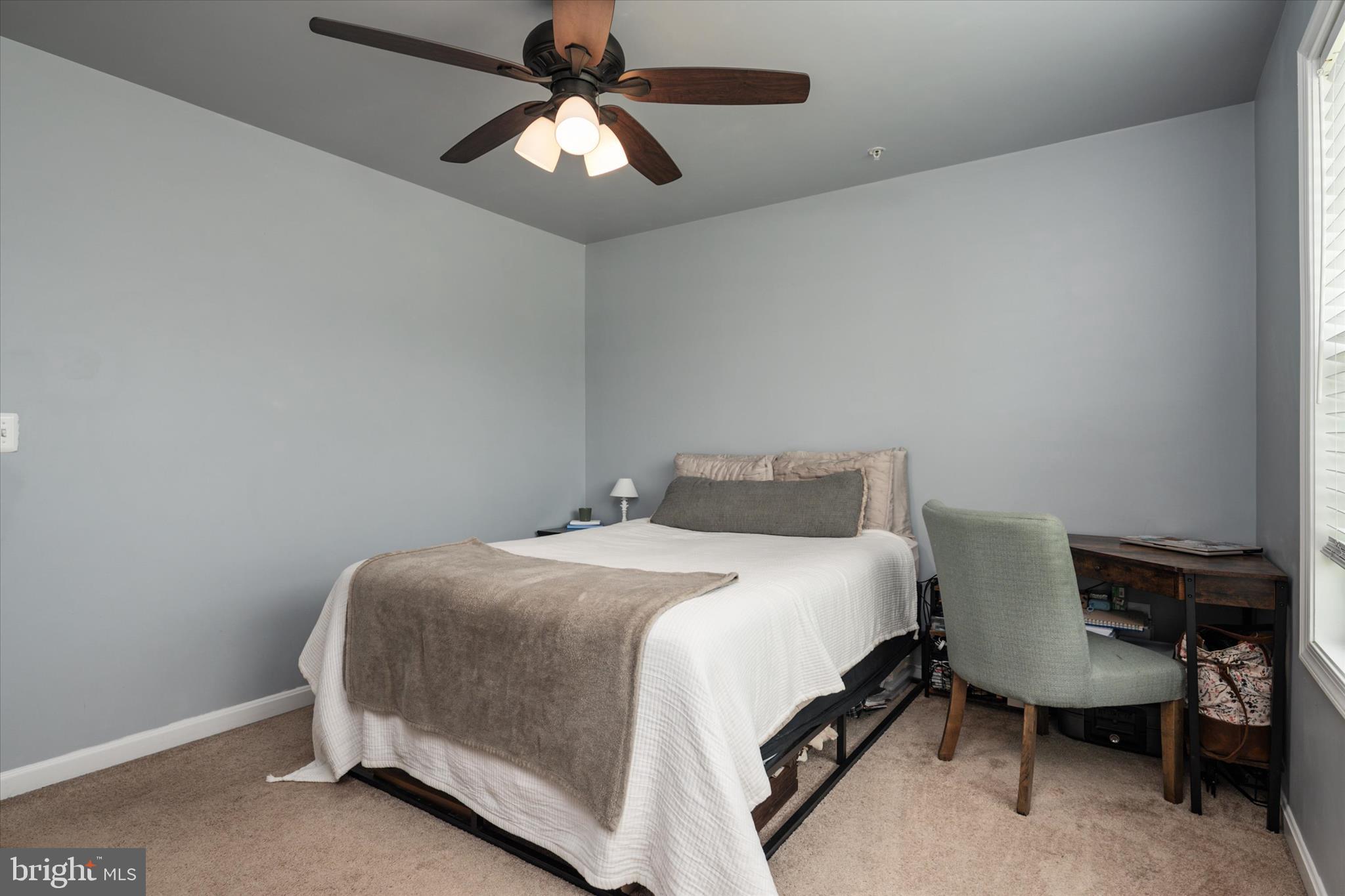 200 Newtown Road Chester, MD 21619 - Photo 23 of 50 a bedroom with a bed a chair and a chandelier
