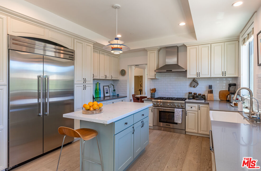 1045 Cold Canyon Road Calabasas, CA 91302 - Photo 16 of 51 a kitchen with stainless steel appliances granite countertop a sink stove and refrigerator