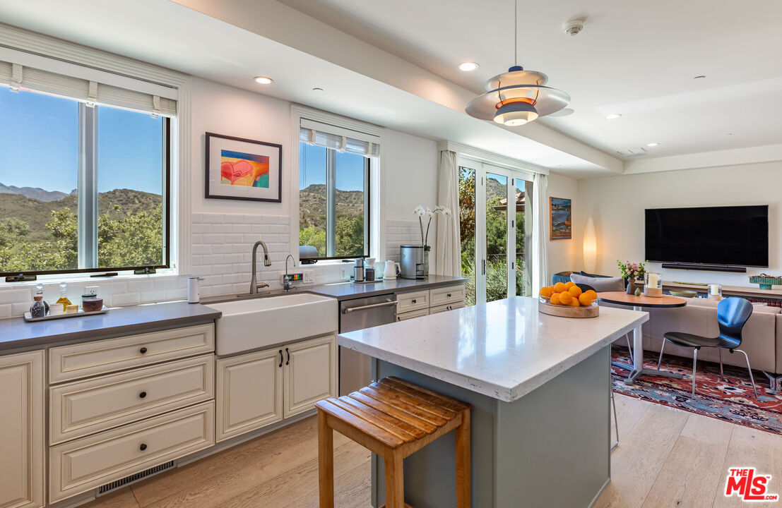 1045 Cold Canyon Road Calabasas, CA 91302 - Photo 17 of 51 a kitchen with a stove a sink dishwasher and a flat screen tv