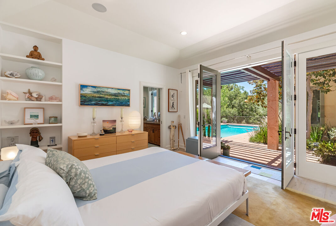 1045 Cold Canyon Road Calabasas, CA 91302 - Photo 26 of 51 a bedroom with a bed and glass window