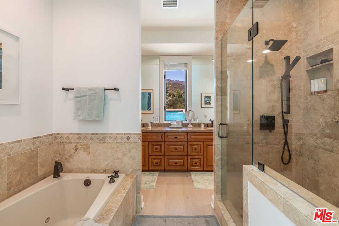 1045 Cold Canyon Road Calabasas, CA 91302 - Photo 29 of 51 a bathroom with a bathtub sink and mirror