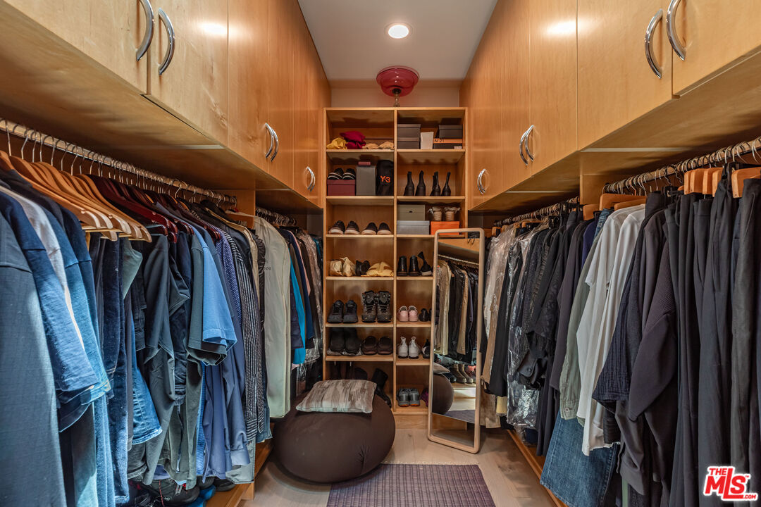 1045 Cold Canyon Road Calabasas, CA 91302 - Photo 30 of 51 a view of walk in closet with clothes and shoes