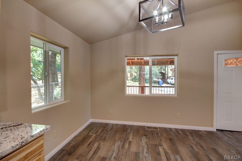 369 Riverside Avenue Sugarloaf, CA 92386 - Photo 13 of 30 a view of an empty room with wooden floor and a window