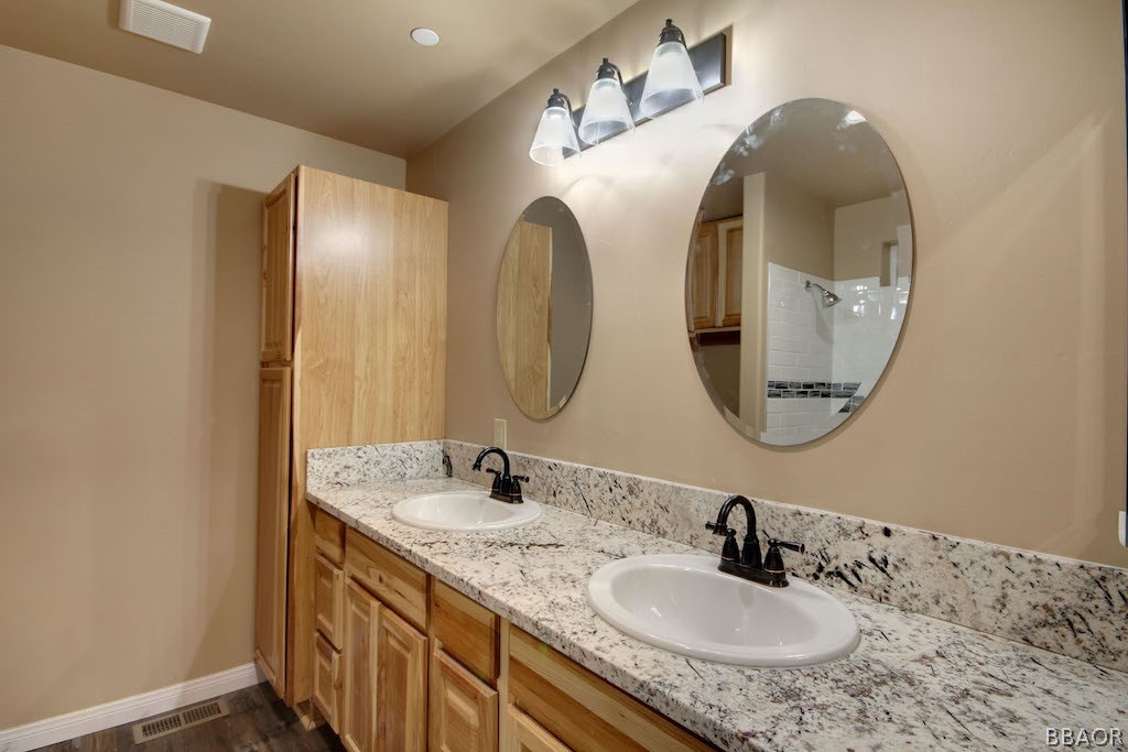 369 Riverside Avenue Sugarloaf, CA 92386 - Photo 20 of 30 a bathroom with a granite countertop double vanity sinks and a mirror