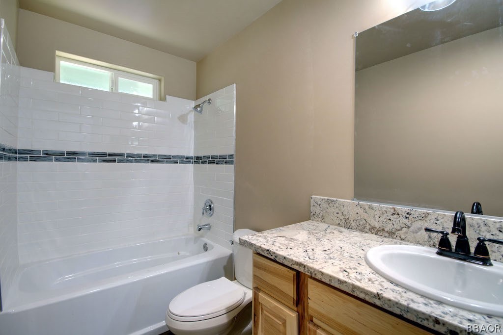 369 Riverside Avenue Sugarloaf, CA 92386 - Photo 25 of 30 a bathroom with a granite countertop bathtub sink vanity mirror and toilet