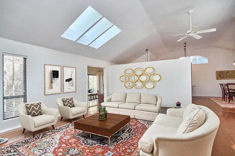 a living room with furniture kitchen view and a chandelier