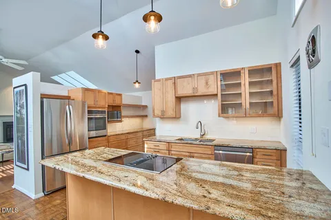 a kitchen with stainless steel appliances granite countertop a sink a stove and a refrigerator