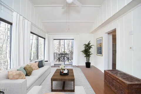 a living room with furniture a chandelier and a window