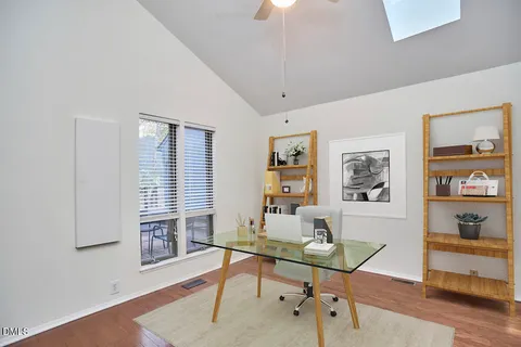 a view of a workspace with furniture and a window